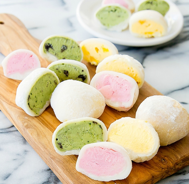An assortment of colorful Japanese mochi ice cream balls, including green tea, strawberry, and vanilla flavors.